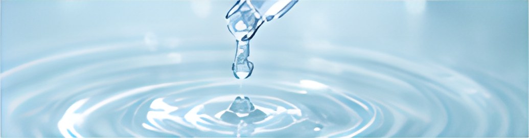 スポイトから水面に落ちる一滴と波紋